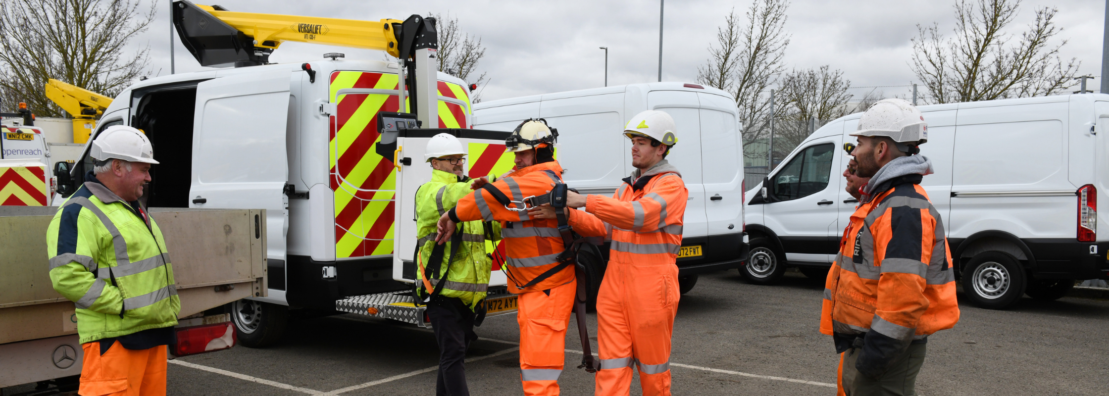 Operator MEWP training with Versalift's IPAF instructor, and trainees getting dressed in proper PPE and harnesses